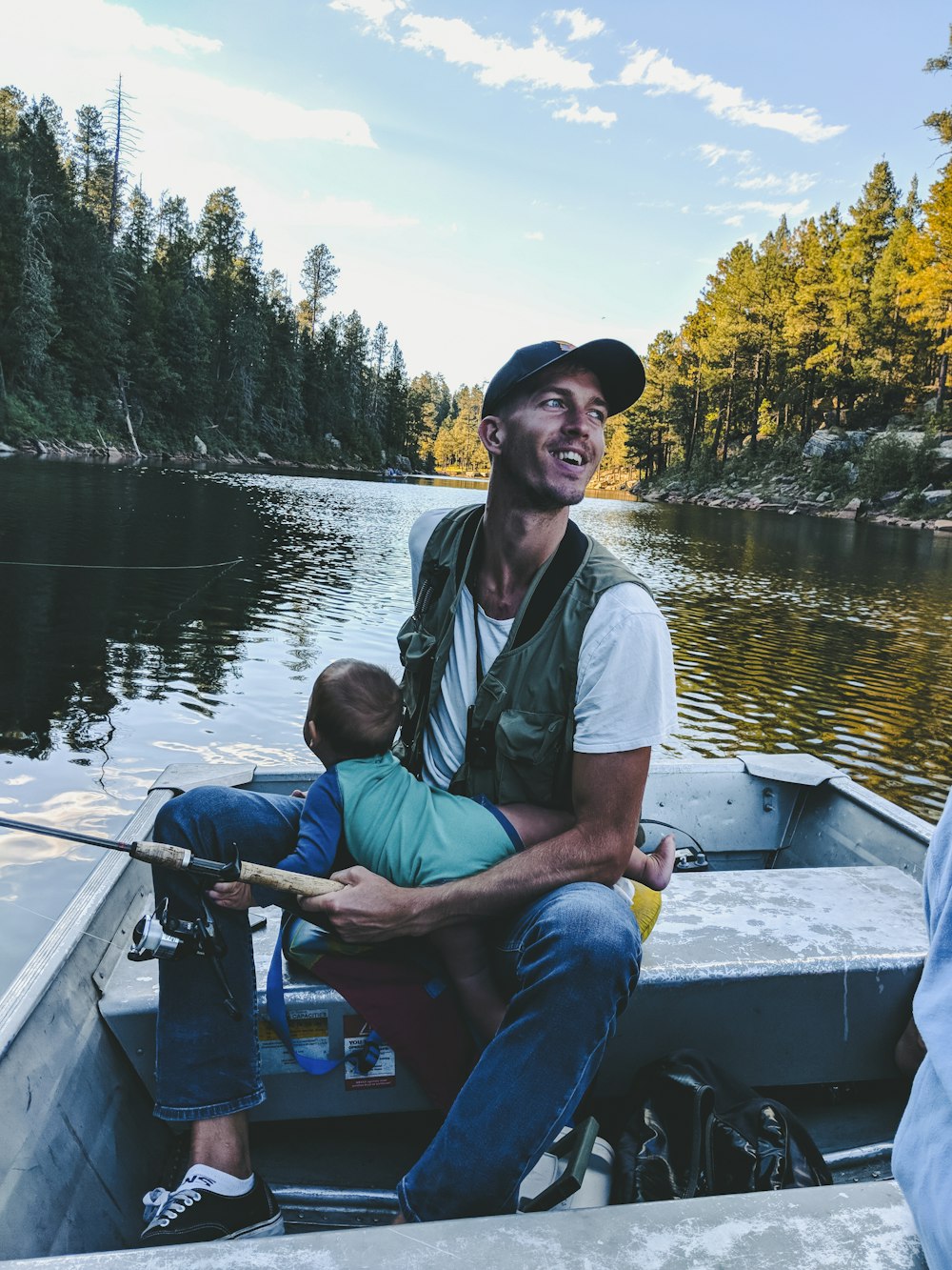 man riding on boat while carrying baby