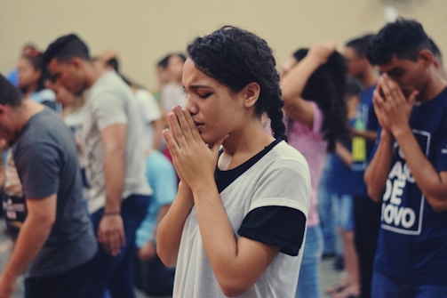 woman  wearing white shirt praying to Jesus