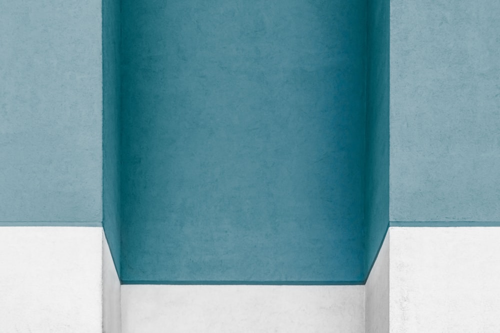 una stanza vuota con un muro blu e un pavimento bianco