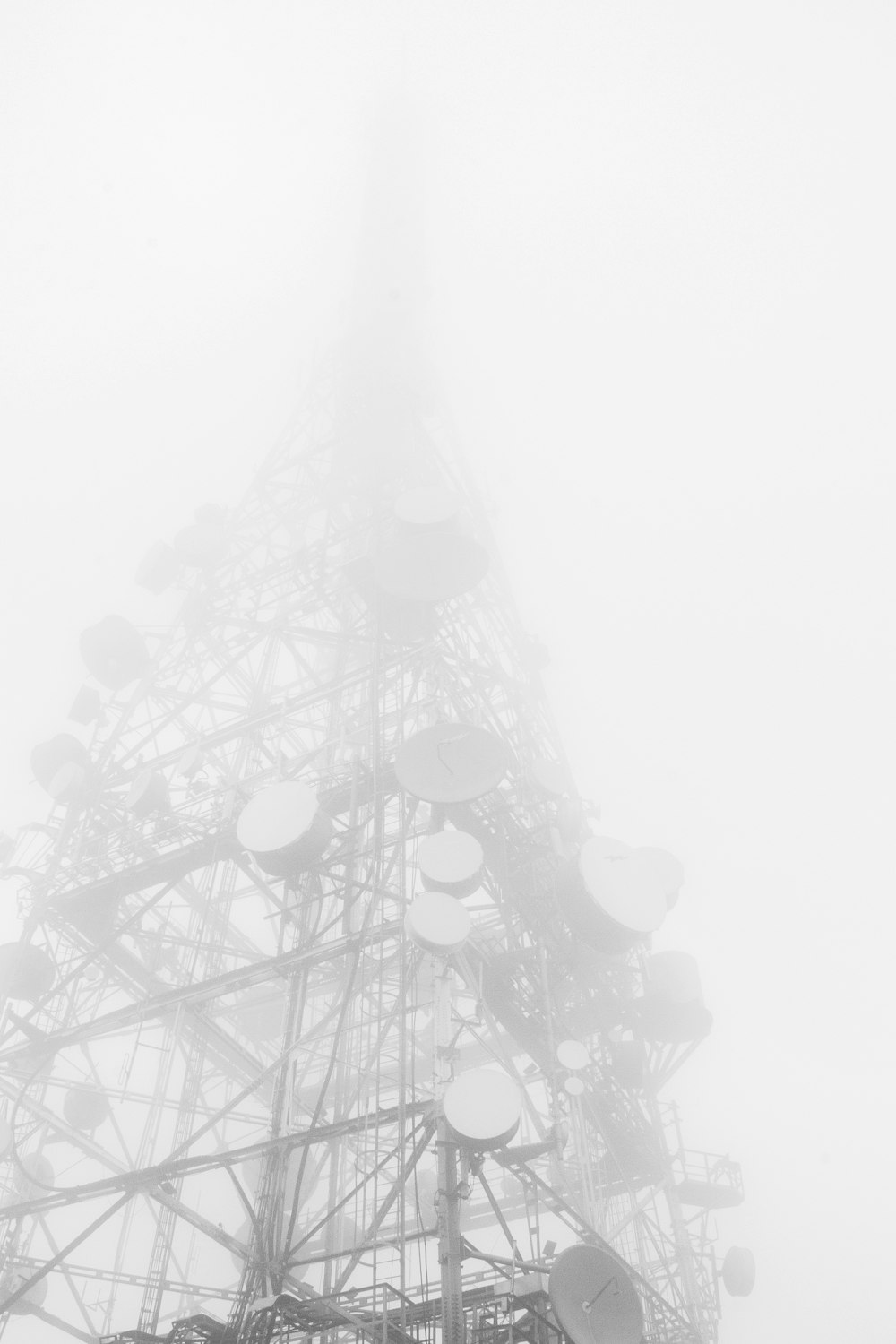 gray telecommunications tower during foggy day