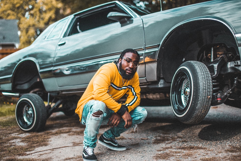 man beside gray coupe