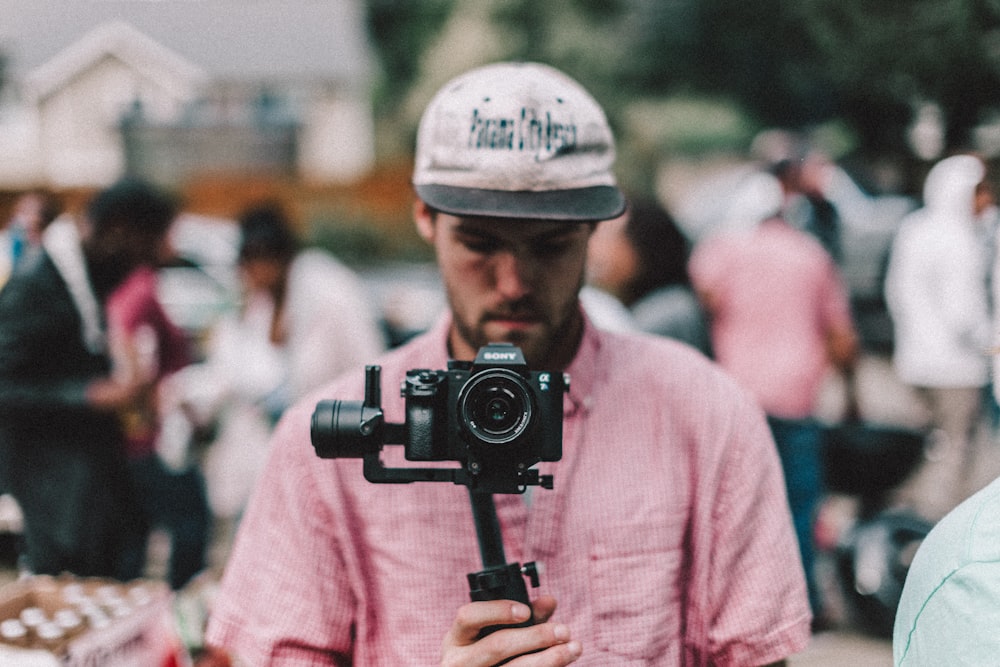 selective focus photography of man holding camera