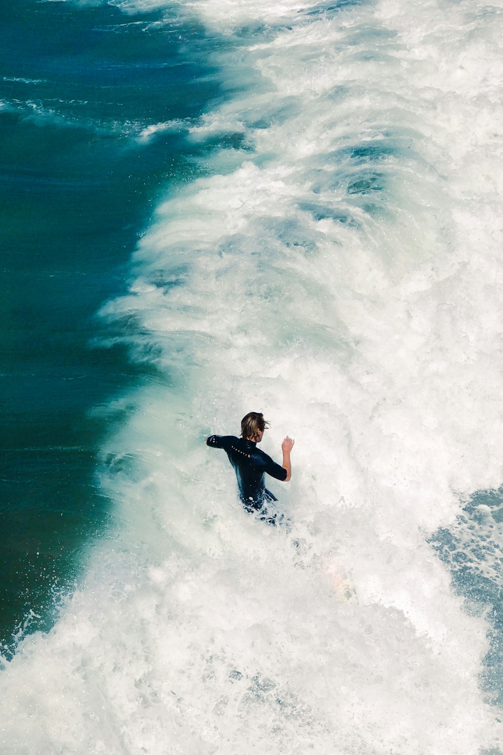 aerial photography of person standing on sea wave