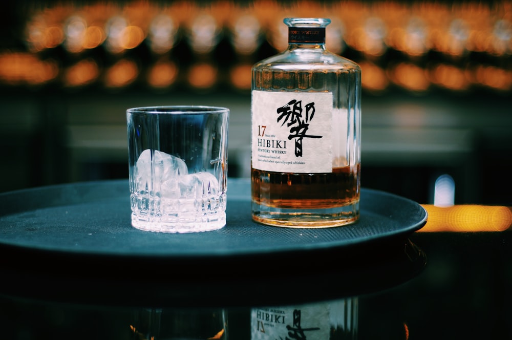 white labeled bottle with rock glass on table