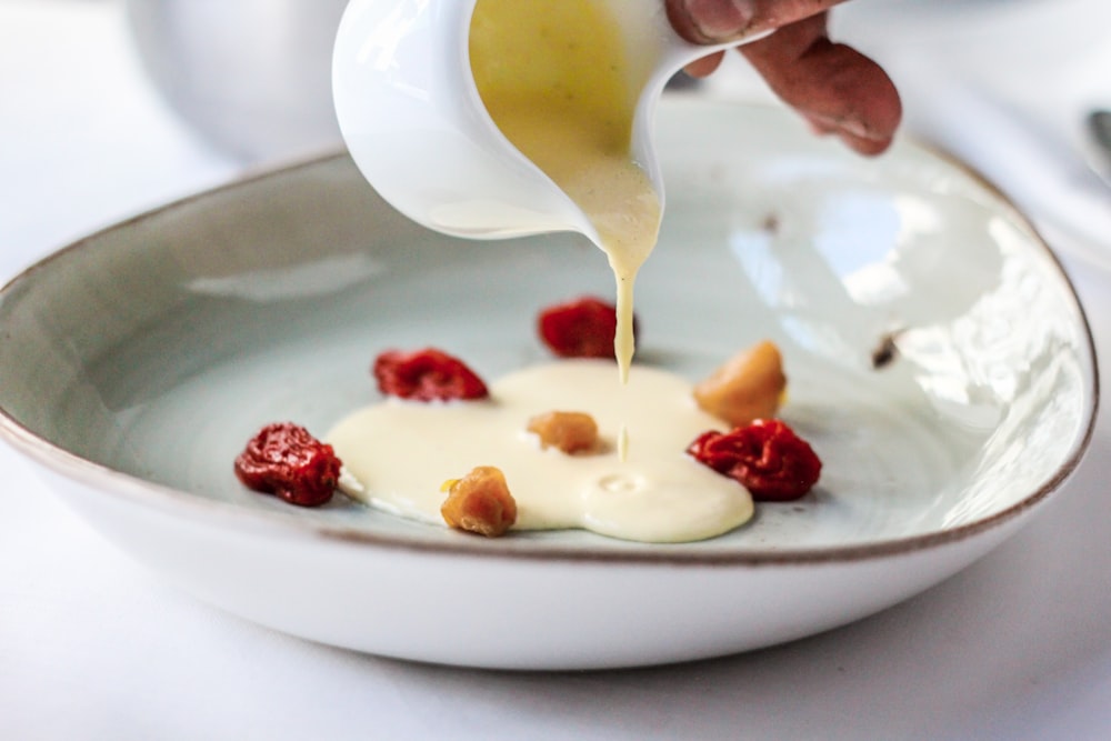 person holding glass pouring cream