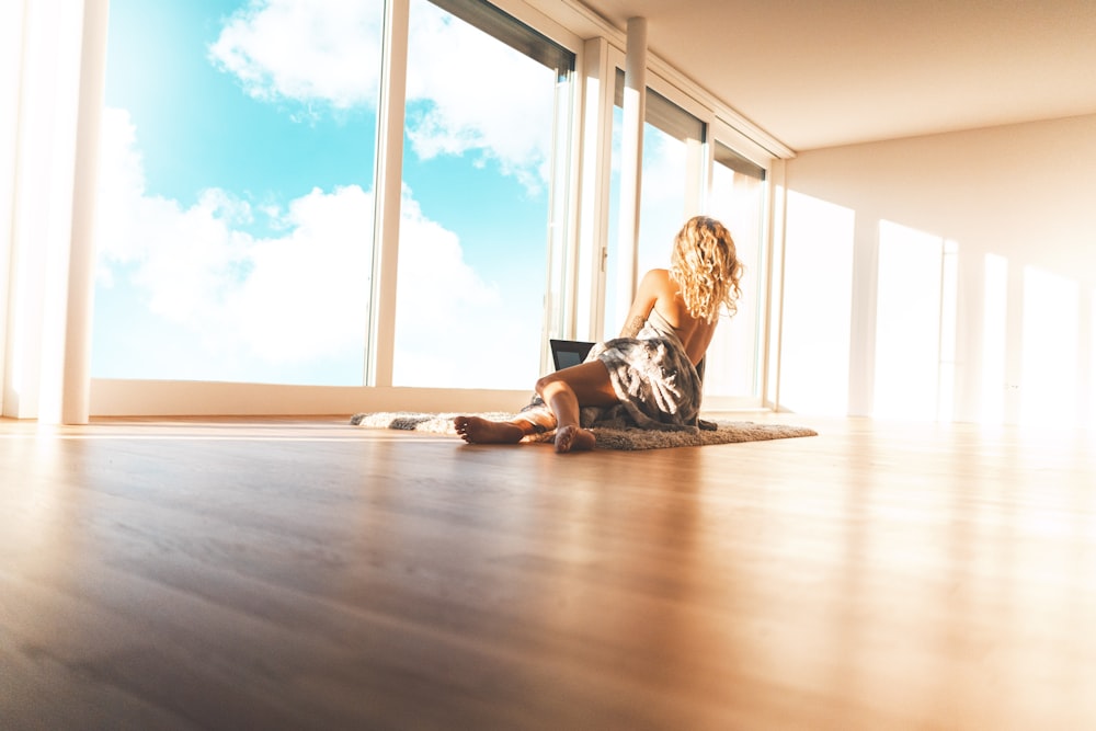 topless woman lying on floor near window