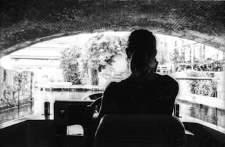 Close-up of hands skillfully steering a motorboat through a narrow canal