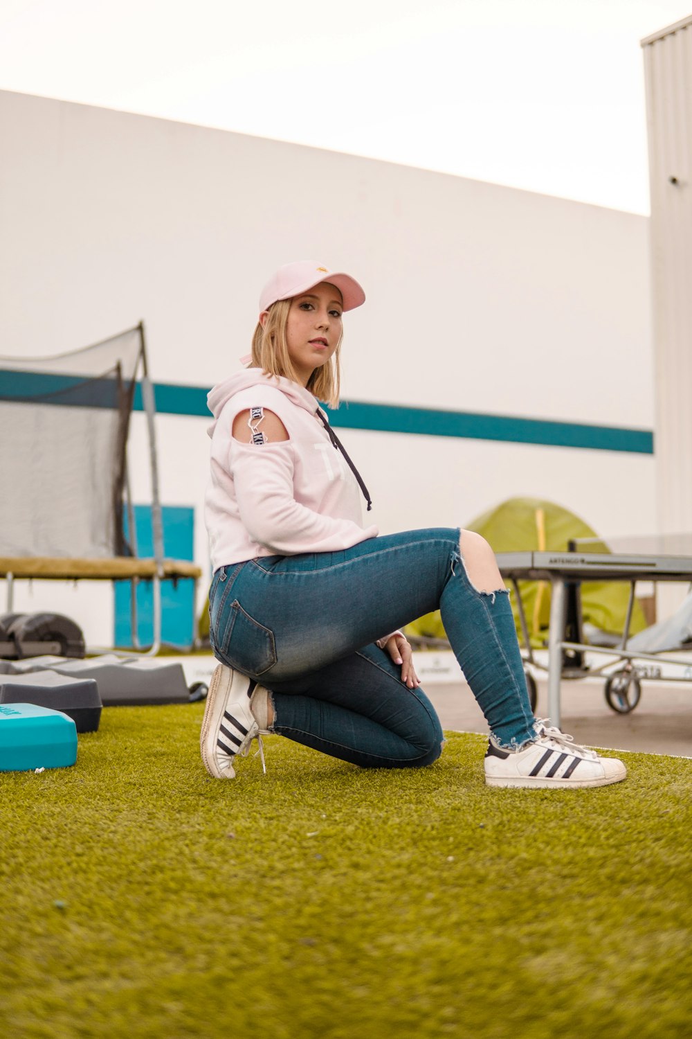 woman wearing pink hoodie and blue denim distressed jeans