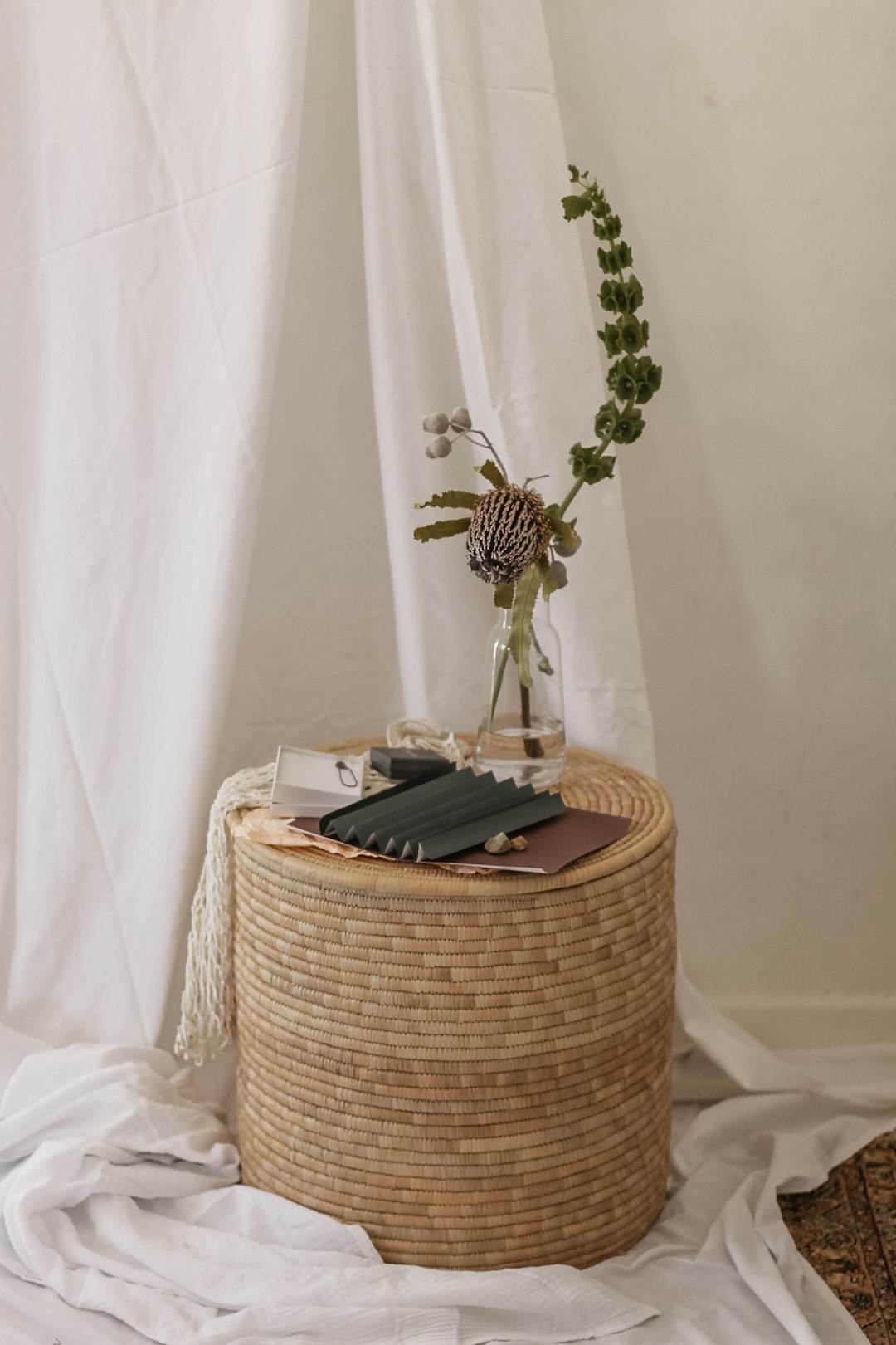 plants in glass bottle on brown wicker table