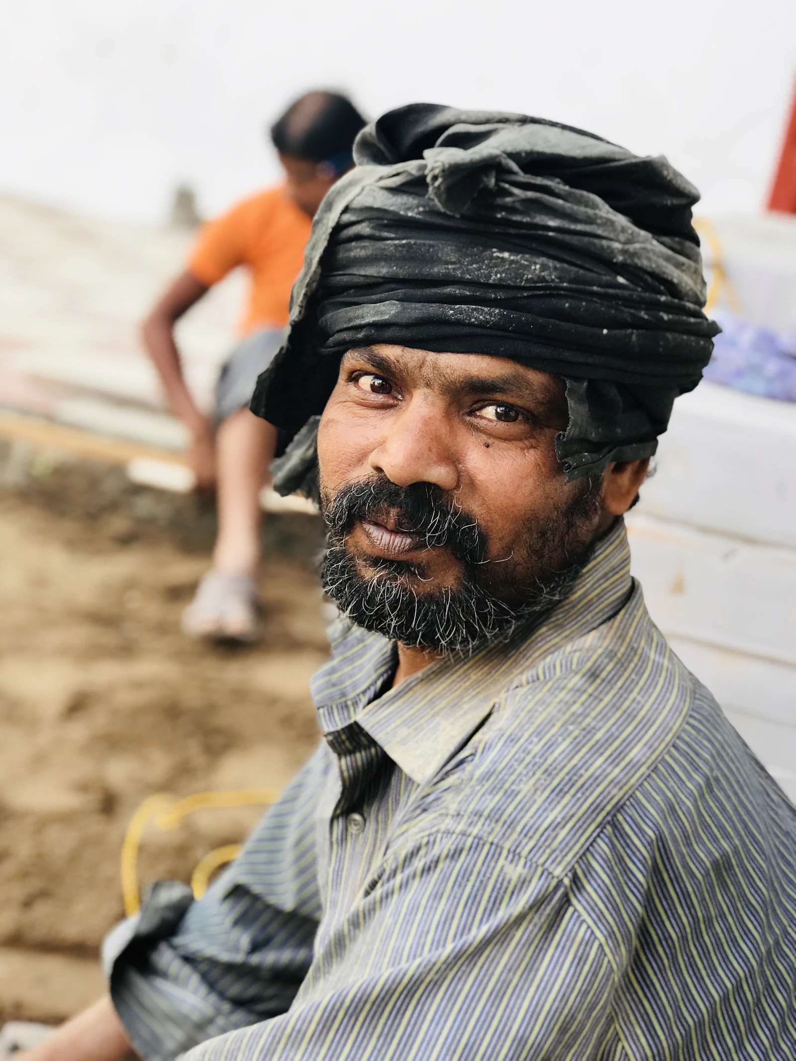 A man in a striped shirt looking towards the camera