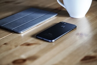 Everyday gadgets arranged neatly on a wooden table with warm light.