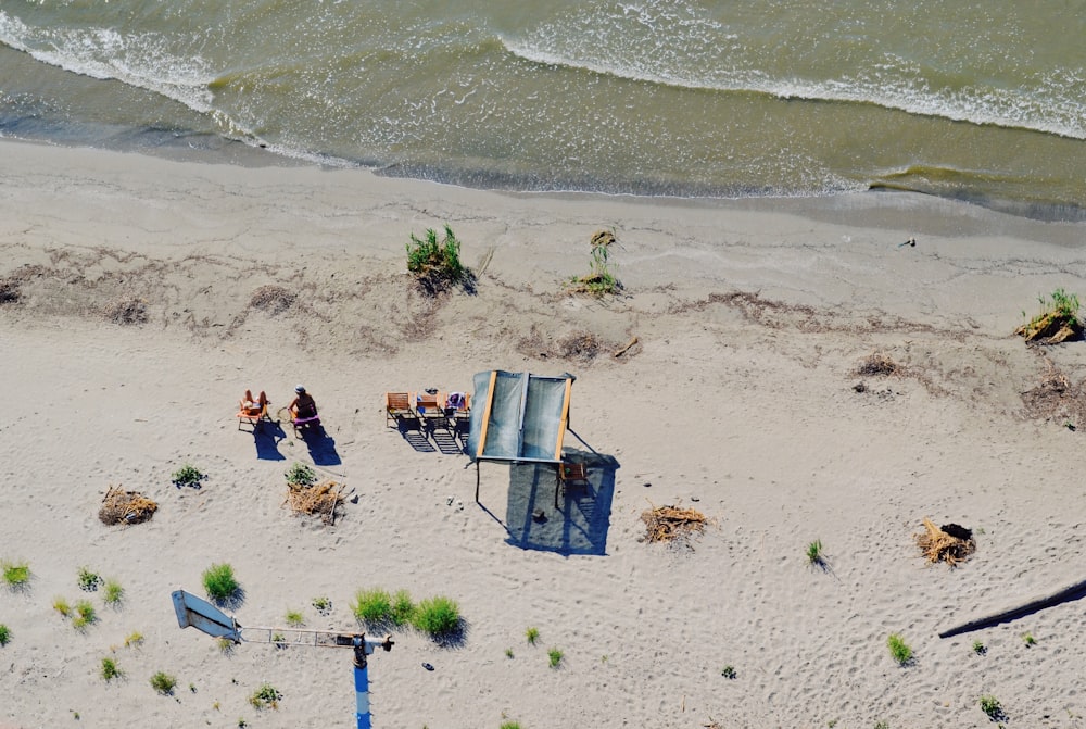 aerial photography of persons sitting beside seashore