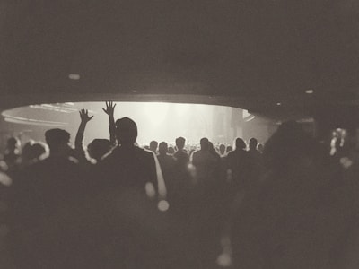 Monochrome image of a keynote speaker addressing a captivated audience in a modern conference hall.