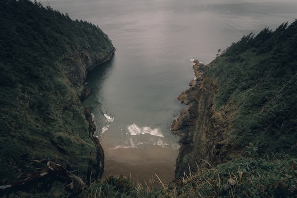 A serene coastal cliffside with waves crashing below, taken from a high drone perspective.