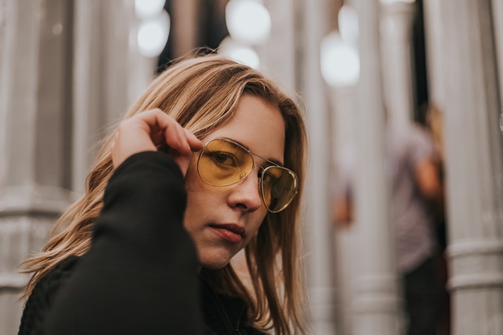 focus of photo of woman holding her sunglasses