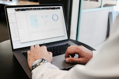 Professional reviewing financial charts on a laptop screen