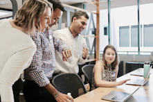 woman sitting at table looking at insurance with coworkers