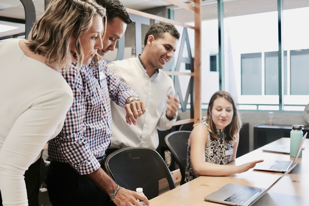 Several people sitting in an office talking to each other.