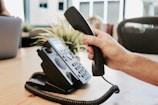 A professional dialing out calls in a modern office, focused and confident.