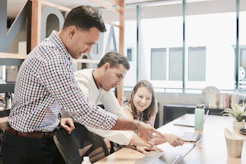 A team collaborating over marketing strategy charts and data on a laptop.