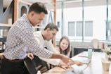 A team of professionals collaborating over a laptop.
