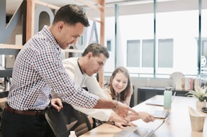 A diverse team collaborating around a laptop, brainstorming ideas.