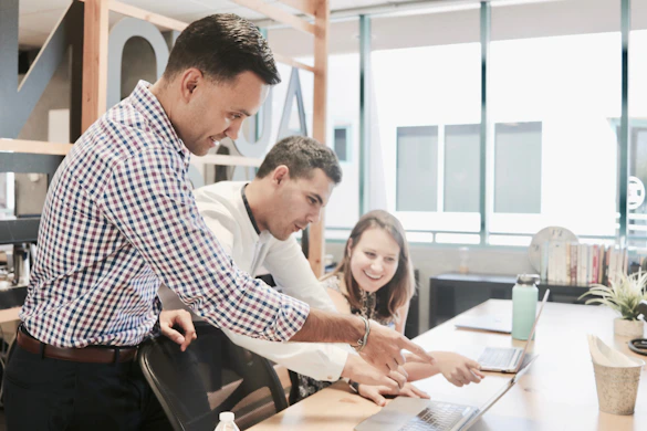 A candid photo of me collaborating with a small team around a laptop in a cozy office space.
