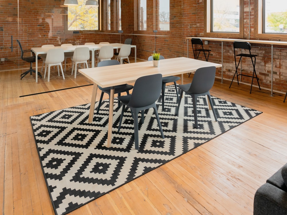 rectangular beige wooden table with four gray chairs