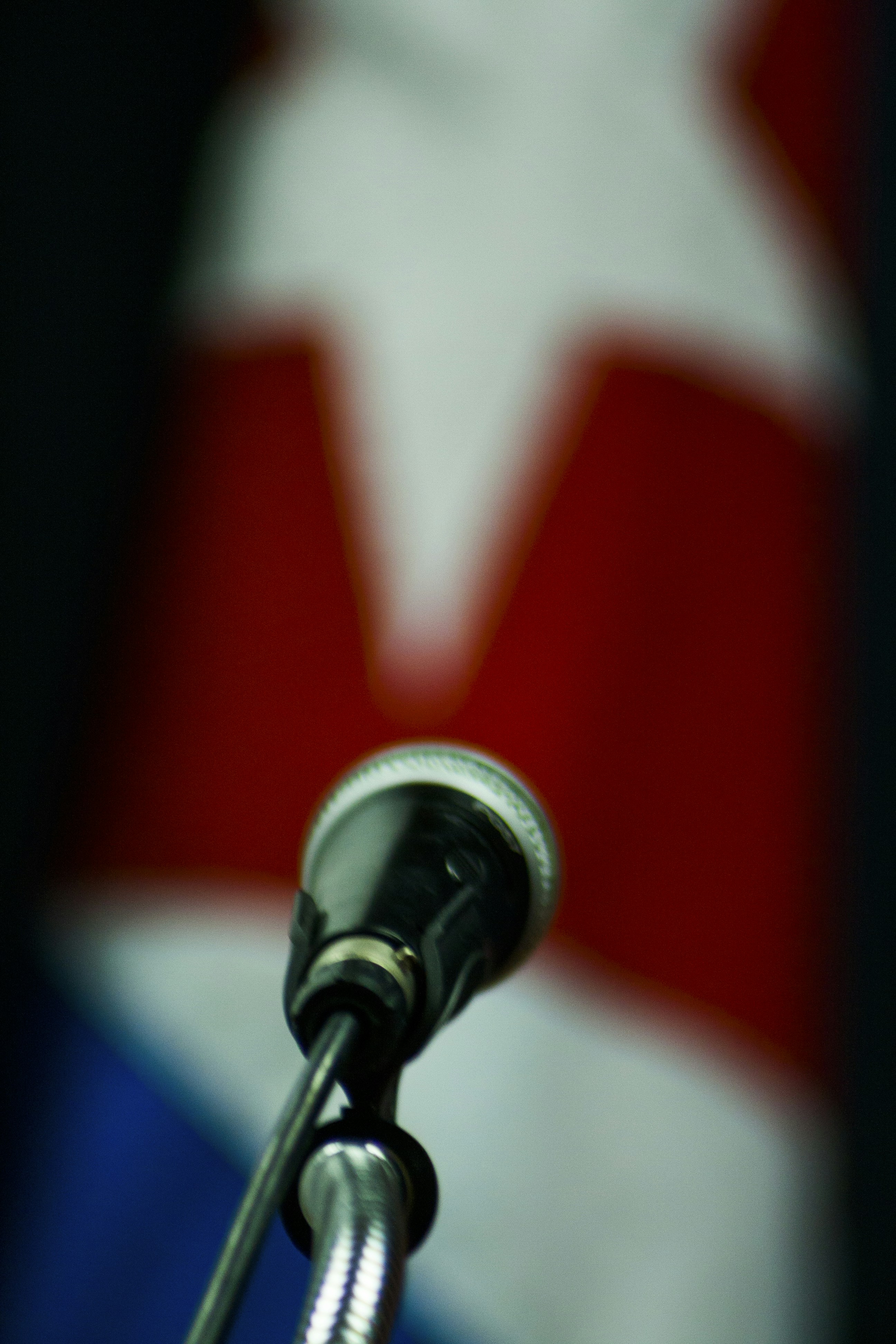 A close-up of a microphone with the 'voz peruana' logo in the background, symbolizing authentic Peruvian voices.