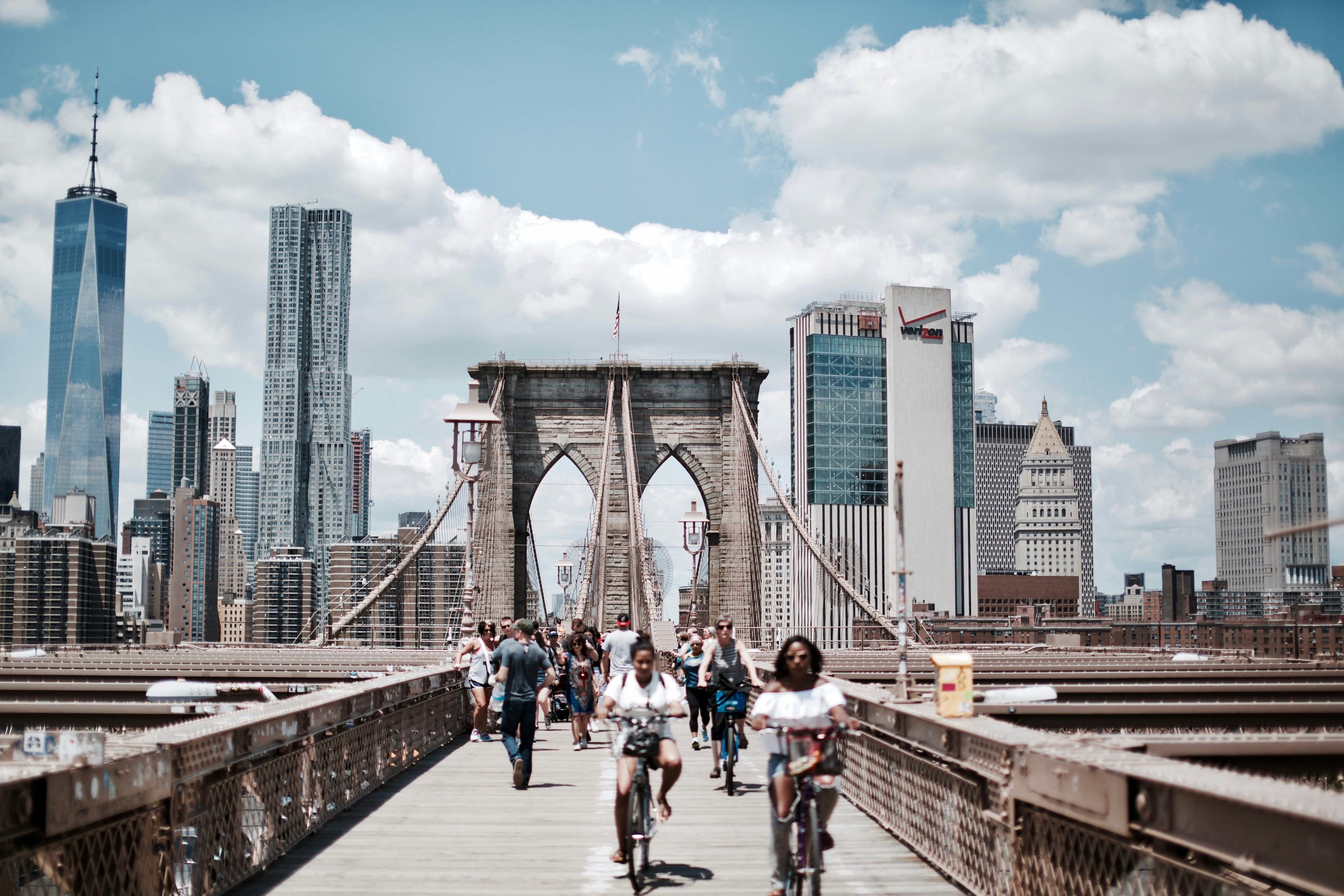 people biking and walking on bridge at daytime