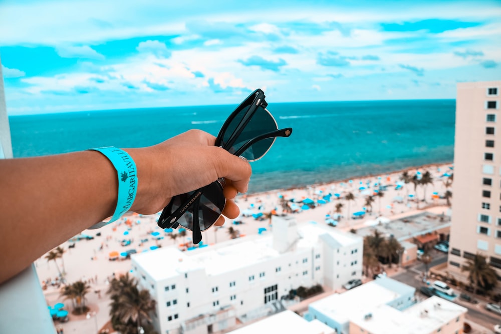 person holding black sunglasses