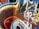 The image features a wall covered in vibrant graffiti with abstract shapes and lines. Prominent colors include red, blue, and yellow with black outlines and white highlights, creating a dynamic and energetic composition. Drips of paint are visible, adding to the urban art feel.