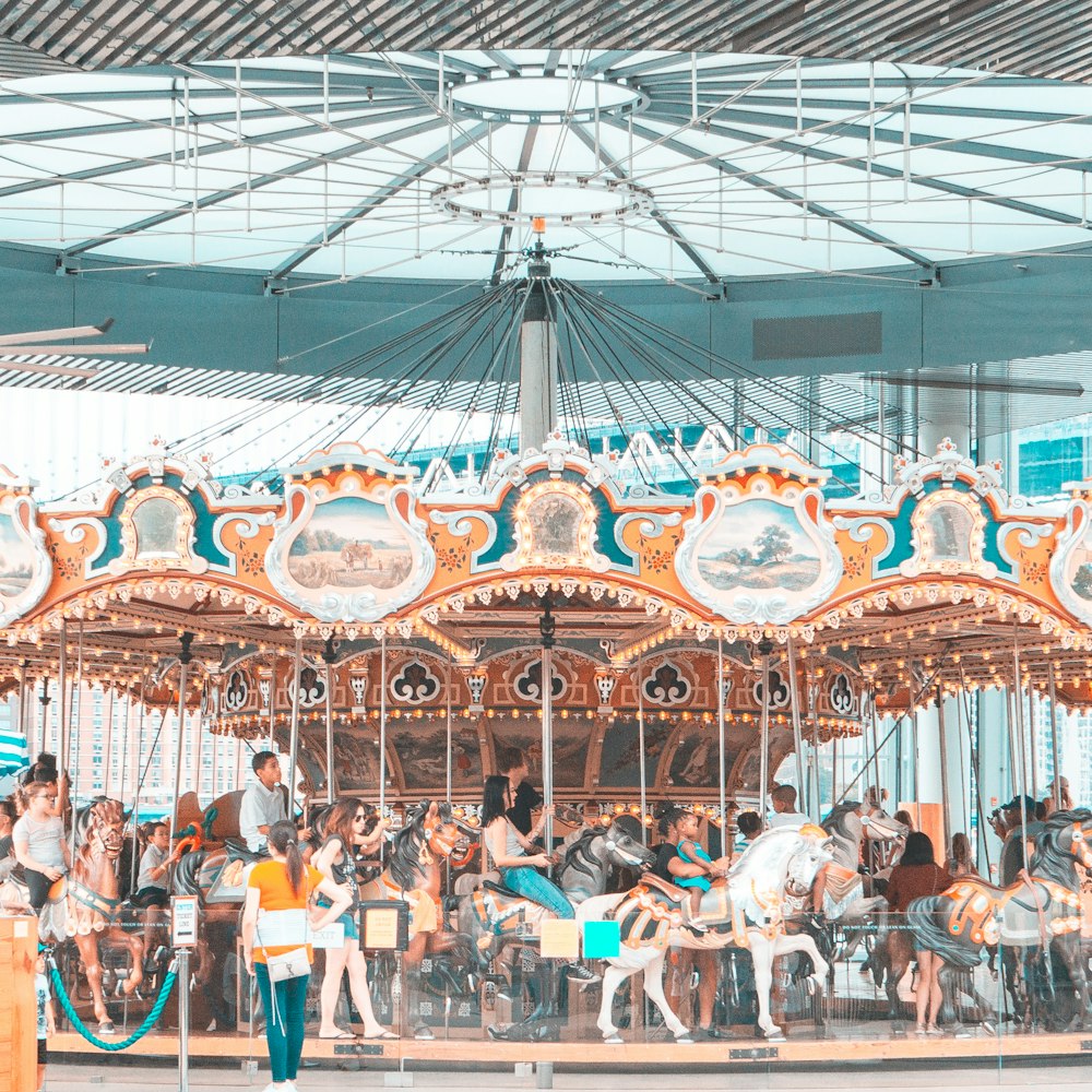 people riding merry go round during daytime