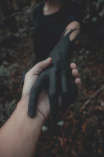 A vibrant close-up of intertwined hands, one painted in yellow, symbolizing connection.