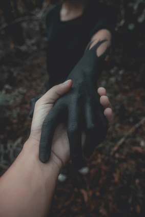 A vibrant close-up of intertwined hands, one painted in yellow, symbolizing connection.