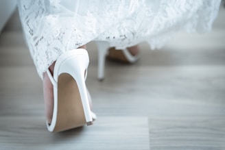 Close-up of elegant women's heels with intricate details on a wooden floor.