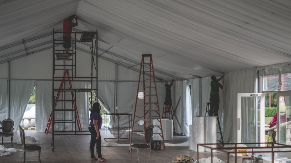 mujer supervisando a un grupo de hombres decorando