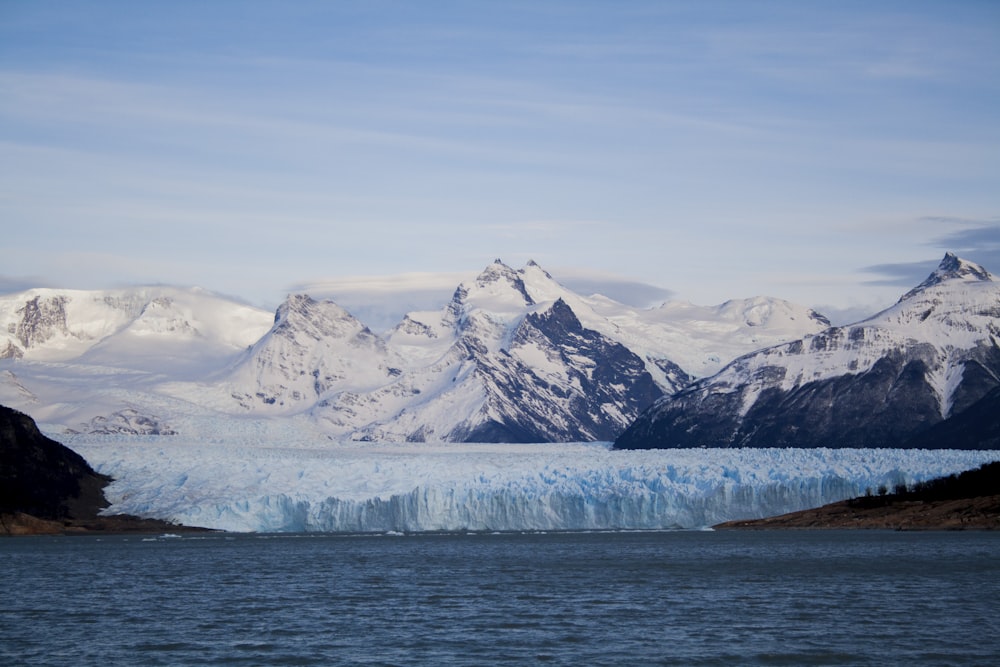 white mountain beside body of water