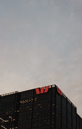 Modern office building with the Barros e Gasparini logo on the facade during sunset.