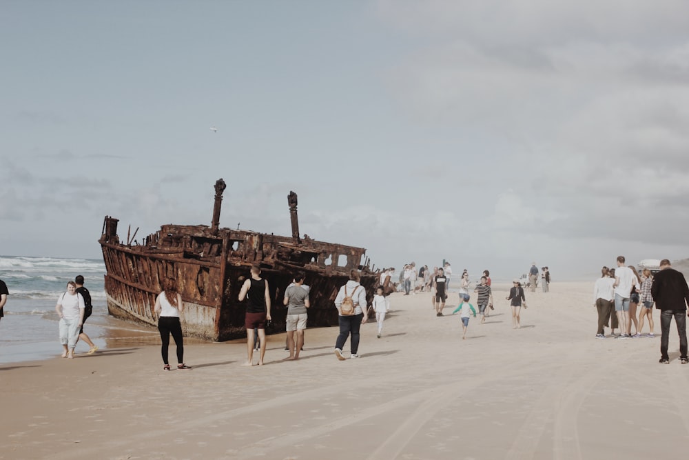 people walking besides brown ship