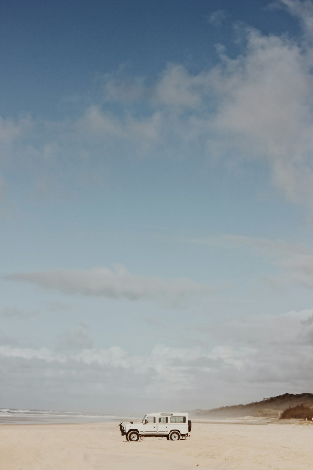 white vehicle near shore under blue sky