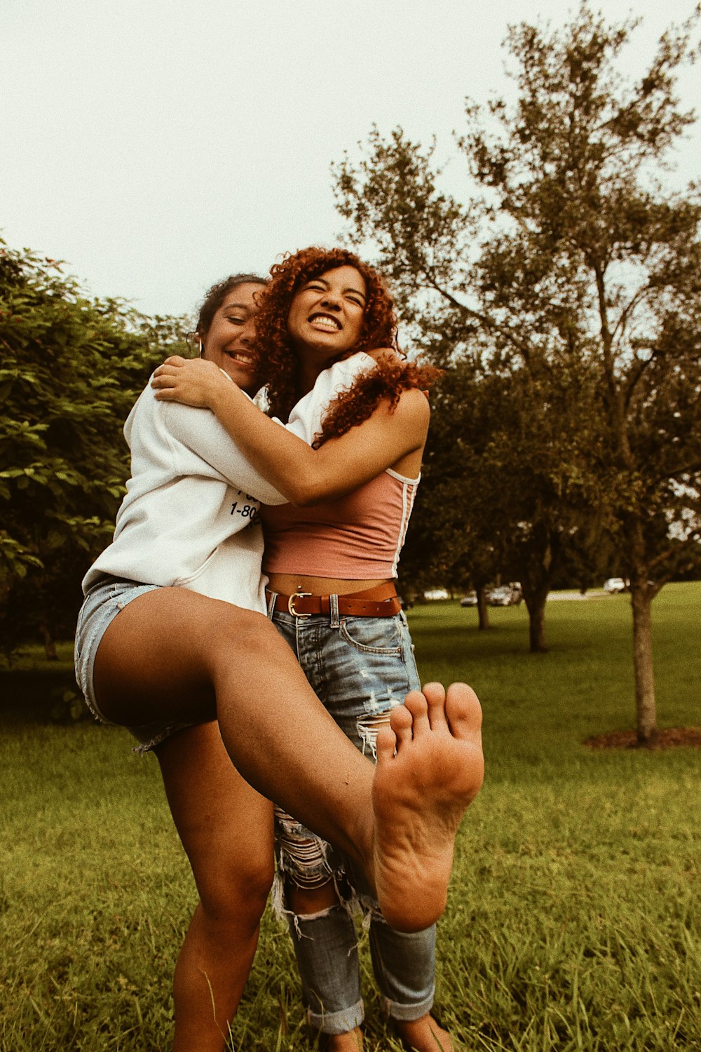 two woman standing near tree photo