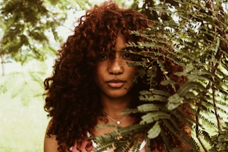 woman standing near green leaves