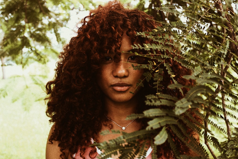 woman standing near green leaves