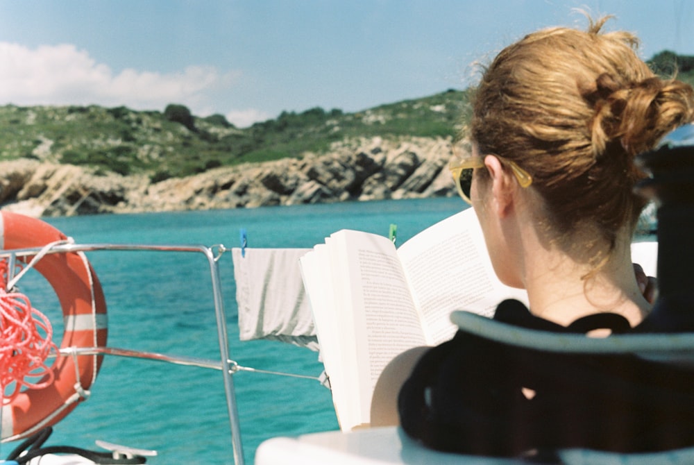 woman reading book on boat
