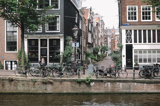 bicycles parked near rail and body of water in Brouwersgracht Netherlands