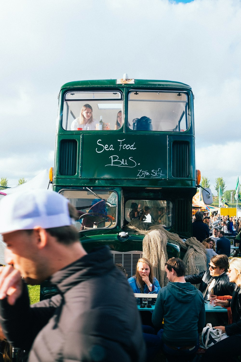 people near green bus during daytime