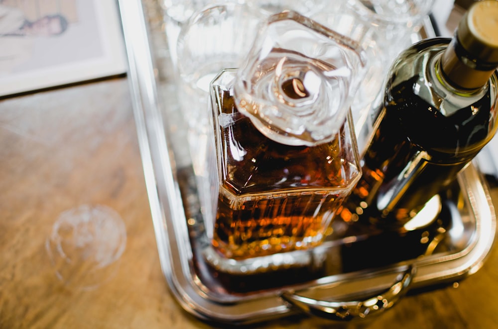 clear glass decanter beside wine bottle on tray