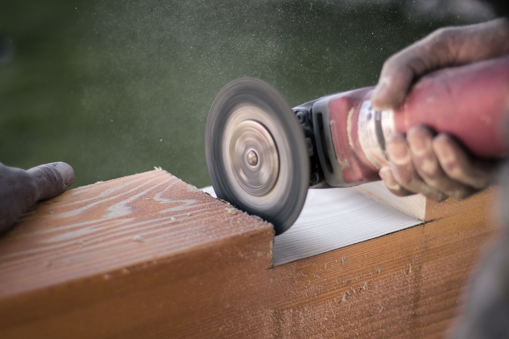 Person using angle grinder cutting the wood frame photo – Free Beverage  Image on Unsplash