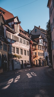 A serene cobblestone street bathed in soft morning light, with delicate shadows from old European buildings.